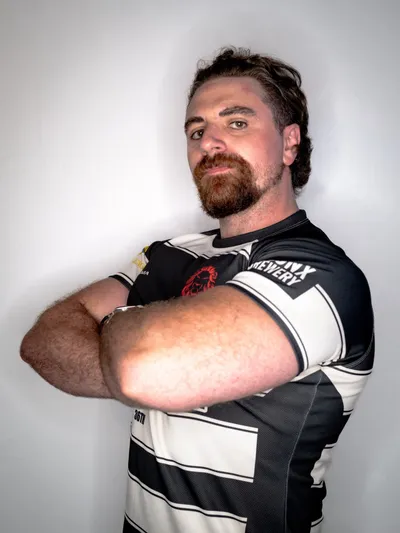 Matt Marano, arms folded, in the club's black and white hooped jersey
