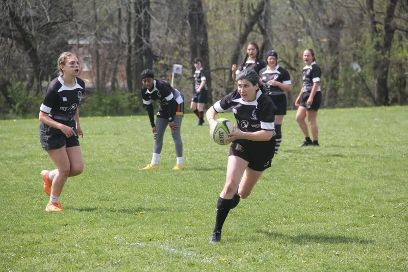 A Women's+ Lions player accelerates with the ball, teammates in support