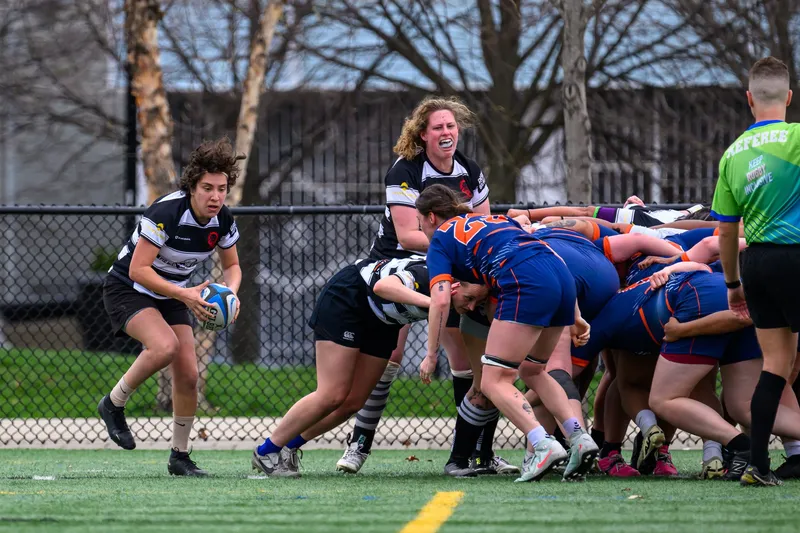 Women's+ Lions forwards drive a maul against a side in blue and orange
