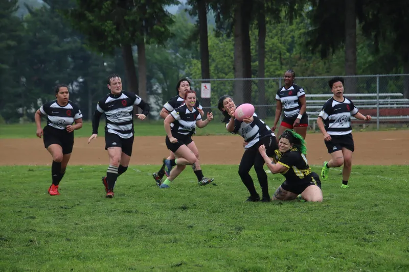 Women's+ Lions players spread wide in attack on a grass pitch